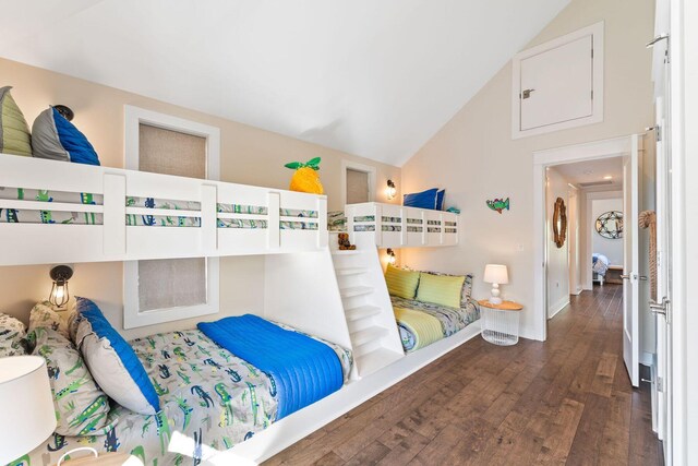 bedroom with high vaulted ceiling and dark wood-type flooring