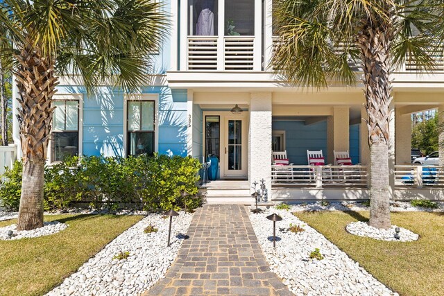 entrance to property featuring ceiling fan and a yard