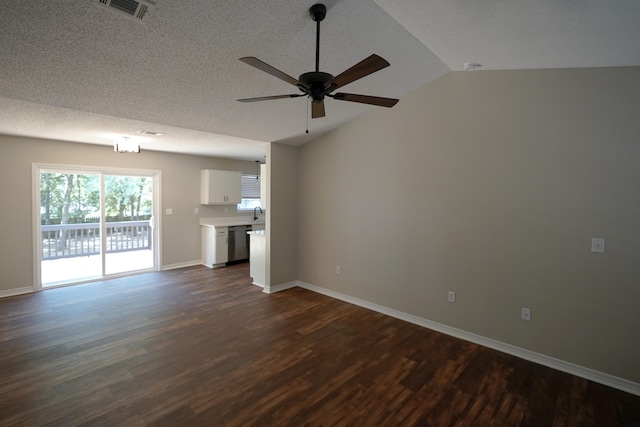 unfurnished living room with ceiling fan, vaulted ceiling, a textured ceiling, and dark hardwood / wood-style flooring