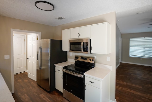 kitchen with appliances with stainless steel finishes, a textured ceiling, and dark hardwood / wood-style flooring