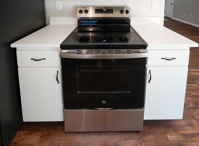 kitchen featuring white cabinetry, light stone counters, electric stove, and dark hardwood / wood-style floors