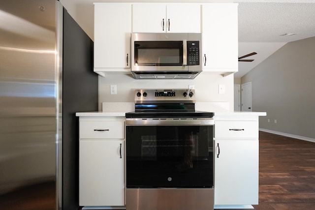 kitchen featuring dark hardwood / wood-style flooring, vaulted ceiling, white cabinetry, and appliances with stainless steel finishes