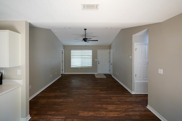 interior space featuring a textured ceiling, dark hardwood / wood-style flooring, and lofted ceiling