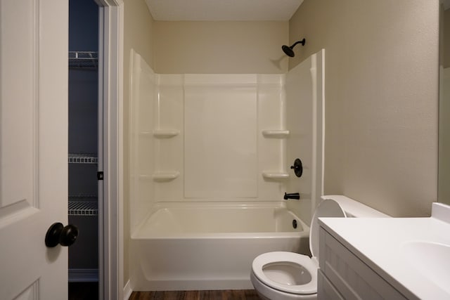 full bathroom with vanity, a textured ceiling, wood-type flooring, toilet, and tub / shower combination