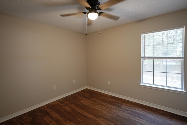 empty room featuring ceiling fan, a textured ceiling, and dark wood-type flooring