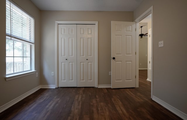 unfurnished bedroom featuring a closet and dark hardwood / wood-style flooring