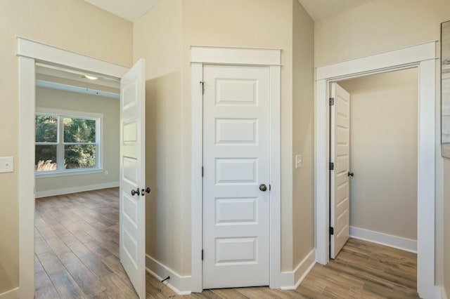 corridor with hardwood / wood-style flooring