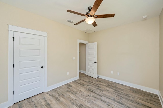 unfurnished bedroom featuring ceiling fan, a closet, and light hardwood / wood-style floors