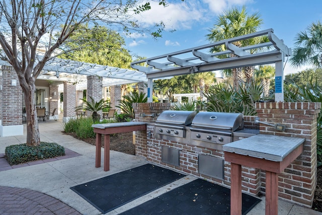 view of patio with a grill, a pergola, and exterior kitchen