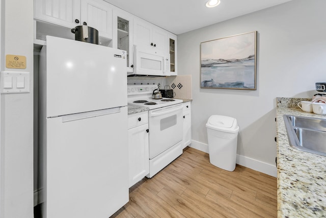 kitchen with white appliances, white cabinetry, baseboards, light wood finished floors, and glass insert cabinets