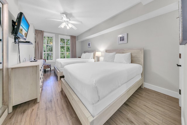 bedroom featuring light wood-style flooring, baseboards, and a ceiling fan