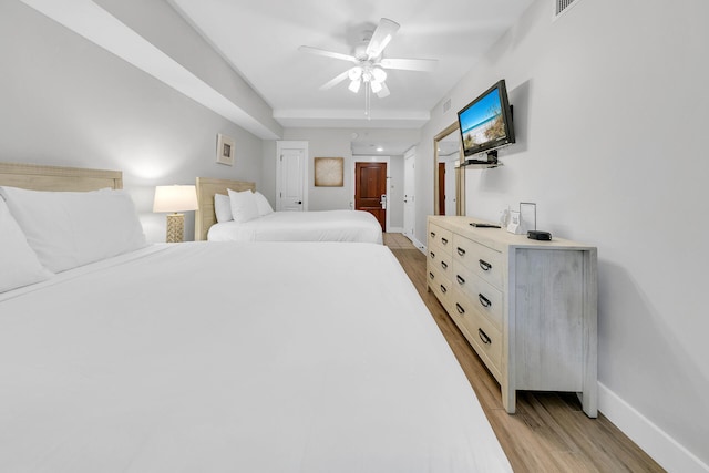 bedroom featuring light wood-style floors, visible vents, ceiling fan, and baseboards