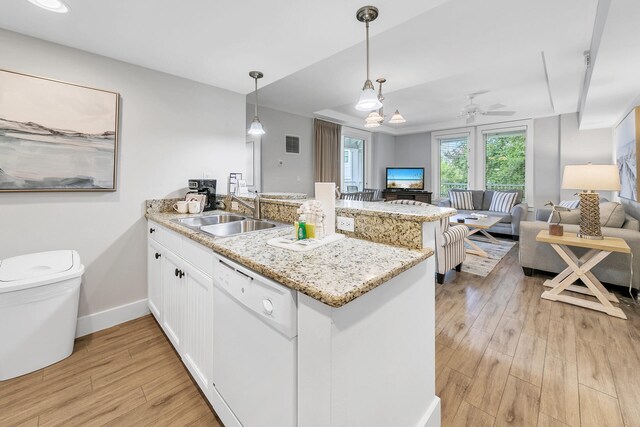 kitchen with white cabinets, dishwasher, ceiling fan with notable chandelier, light hardwood / wood-style floors, and sink