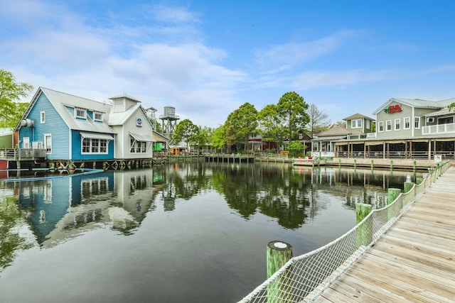 view of dock with a residential view and a water view