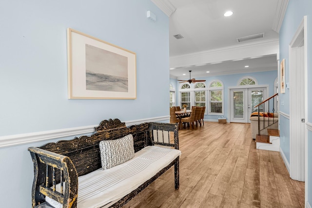 hall featuring light wood-type flooring and crown molding