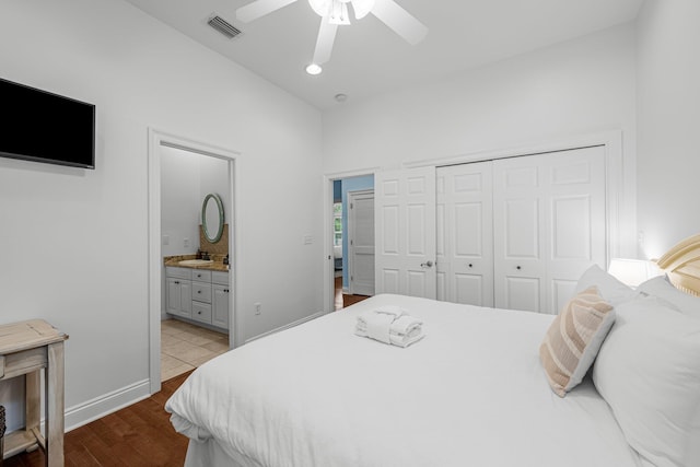 bedroom with light wood-type flooring, ceiling fan, a closet, vaulted ceiling, and ensuite bathroom