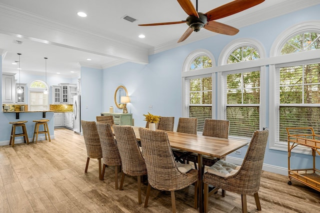 dining space featuring ceiling fan, ornamental molding, and light hardwood / wood-style flooring