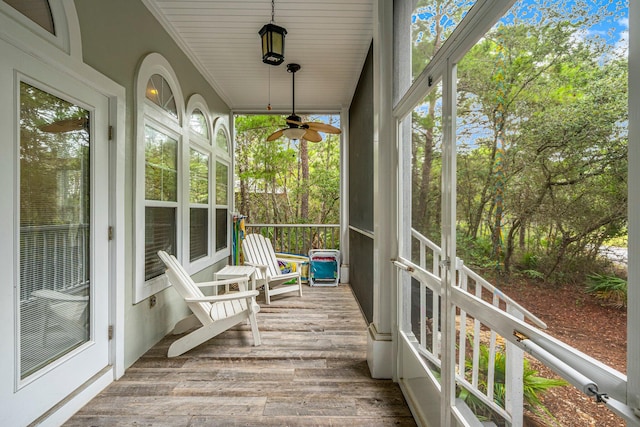 unfurnished sunroom featuring ceiling fan