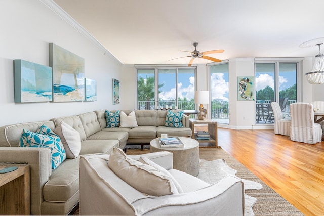 living room with crown molding, light hardwood / wood-style flooring, and ceiling fan