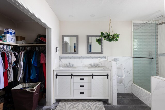 bathroom featuring tiled shower, vanity, and tile patterned floors