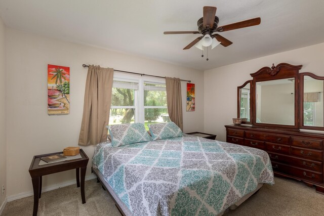 carpeted bedroom featuring ceiling fan and multiple windows