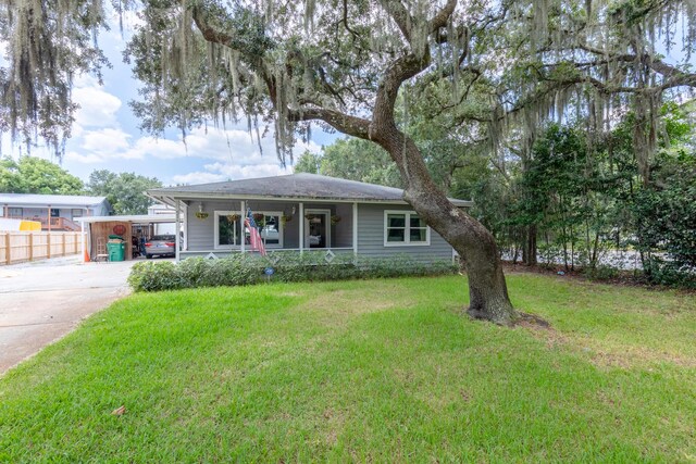 single story home featuring covered porch and a front lawn