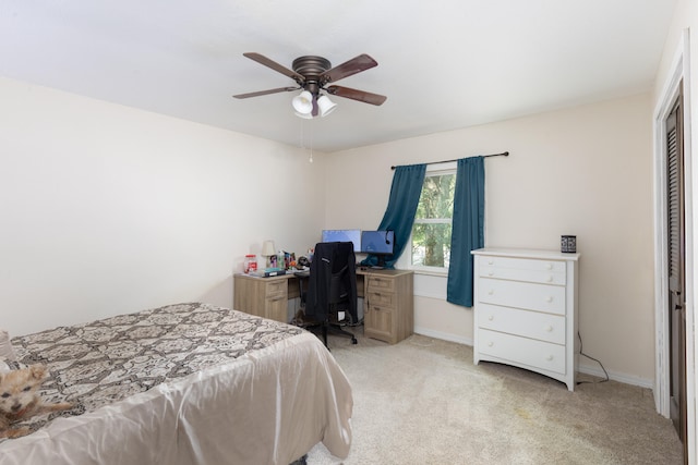 bedroom with ceiling fan, light colored carpet, and a closet