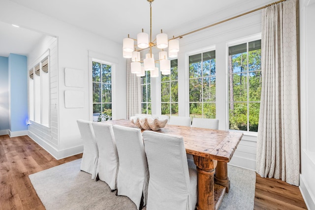 dining space featuring light wood-type flooring and an inviting chandelier