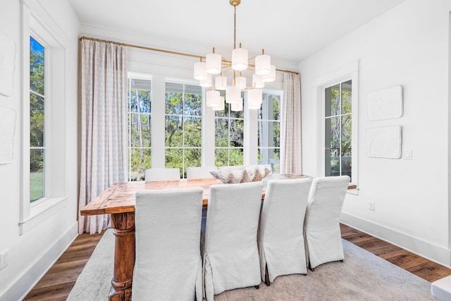 dining area with a notable chandelier, dark hardwood / wood-style flooring, and a healthy amount of sunlight