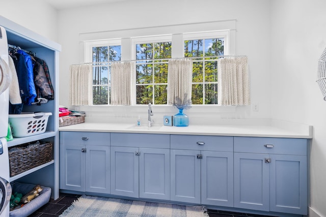 interior space with sink, dark tile patterned floors, and a healthy amount of sunlight