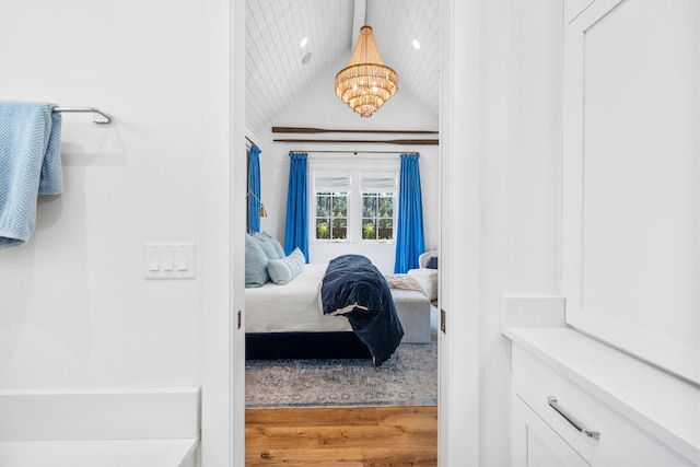 bedroom featuring lofted ceiling, a chandelier, and hardwood / wood-style flooring