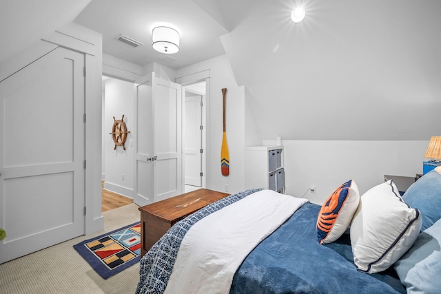 bedroom with lofted ceiling and light wood-type flooring