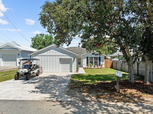 view of front facade with a garage, driveway, fence, board and batten siding, and a front yard