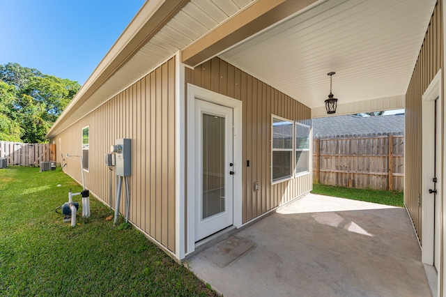 property entrance featuring a yard, a patio, and central AC unit