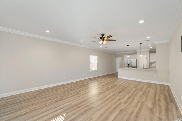 unfurnished living room featuring light hardwood / wood-style floors, crown molding, sink, and ceiling fan