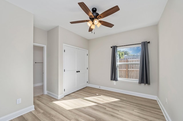 unfurnished bedroom featuring a closet, light hardwood / wood-style floors, and ceiling fan