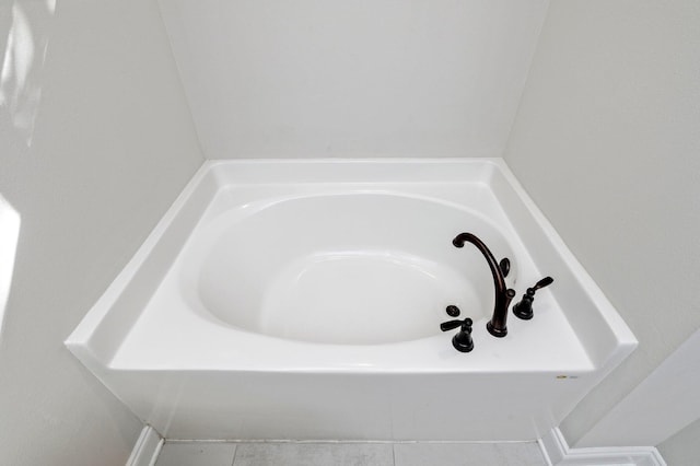 interior details with tile patterned floors and a bathtub