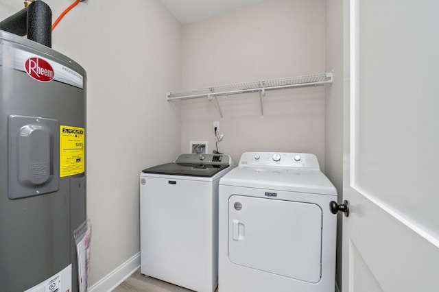 laundry room with water heater and washer and clothes dryer