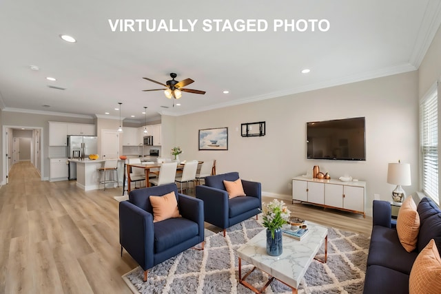 living room featuring light hardwood / wood-style flooring, ornamental molding, and ceiling fan