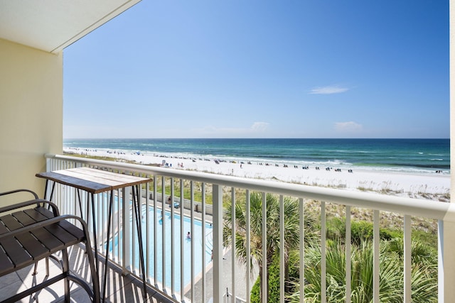 balcony featuring a view of the beach and a water view