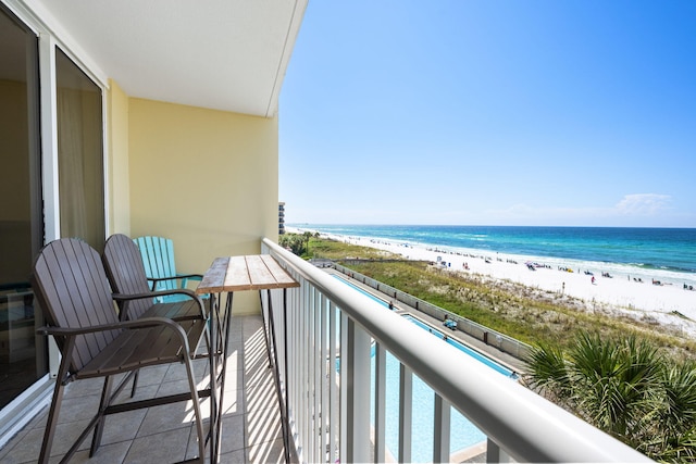 balcony featuring a water view and a beach view