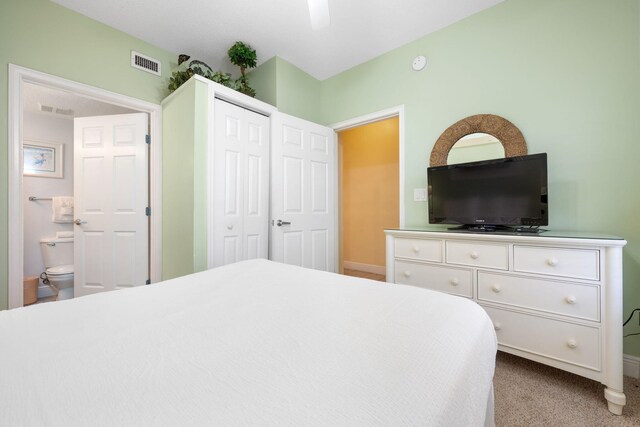 carpeted bedroom with connected bathroom and ceiling fan