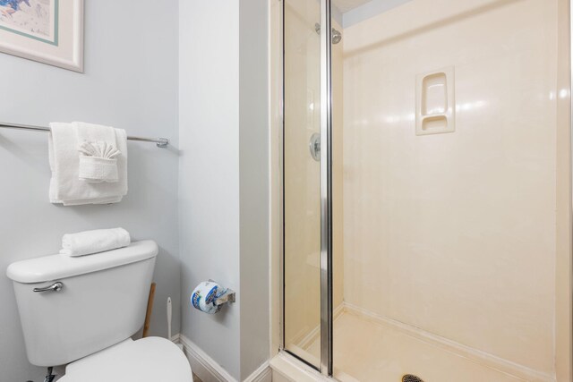 bathroom with toilet and a shower with shower door