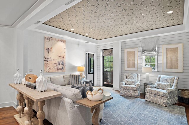 living room featuring a tray ceiling and hardwood / wood-style flooring