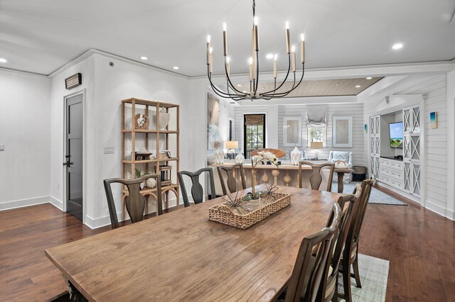 dining room with dark wood-type flooring, a notable chandelier, and ornamental molding