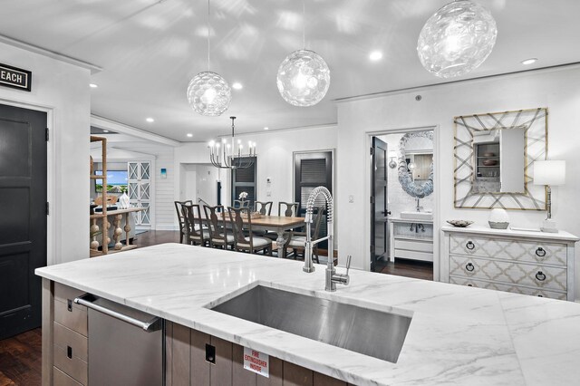 kitchen with light stone counters, dark hardwood / wood-style floors, sink, and decorative light fixtures