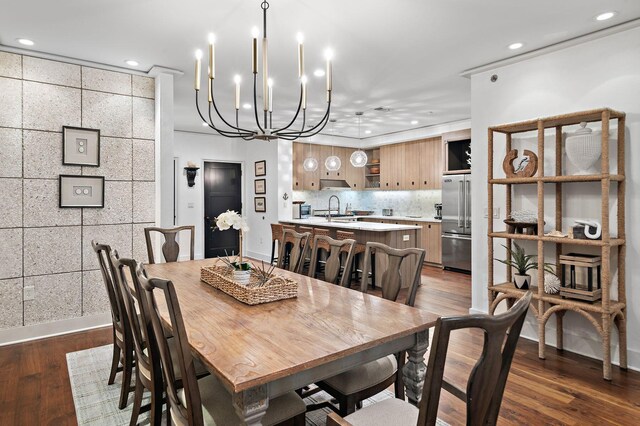 dining area featuring dark hardwood / wood-style floors, sink, and a chandelier