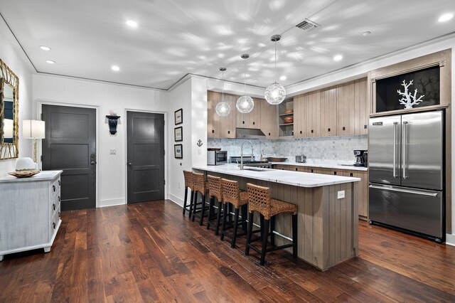 kitchen featuring dark hardwood / wood-style floors, a breakfast bar area, kitchen peninsula, stainless steel built in refrigerator, and tasteful backsplash