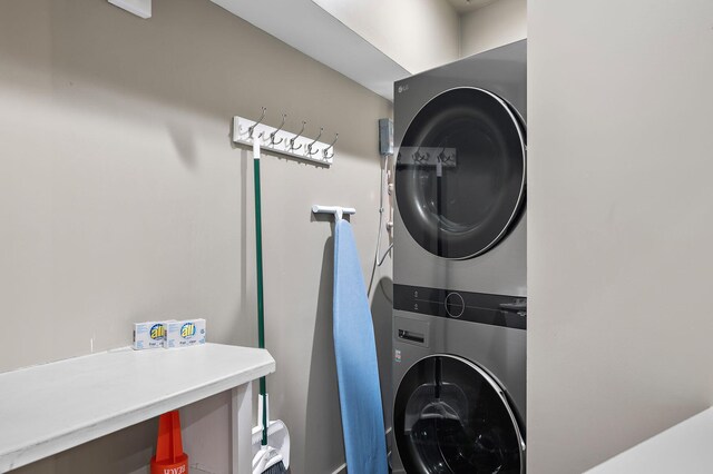 clothes washing area featuring stacked washer and clothes dryer