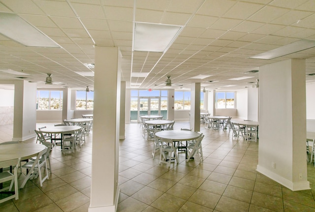 tiled dining area featuring a water view, plenty of natural light, and ceiling fan